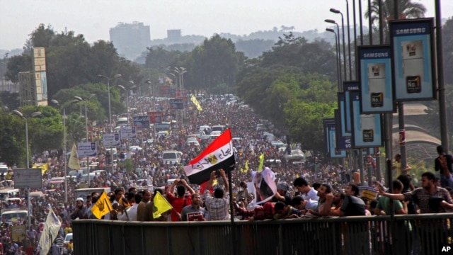 Supporters of Egypt's ousted president Mohamed Morsi stand on a bridge as they march during his trial in Cairo, Egypt, Nov. 4 2013.