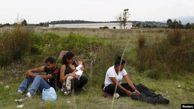 FILE - A group of Central American immigrants sit between vegetation for fear of organized crime bands in Huehuetoca, near Mexico City, June 1, 2015. An increasing number of Central Americans are sneaking across Mexico's border en route to the United States.