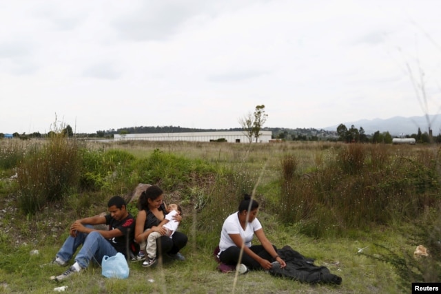 FILE - A group of Central American immigrants sit between vegetation for fear of organized crime bands in Huehuetoca, near Mexico City, June 1, 2015. An increasing number of Central Americans are sneaking across Mexico's border en route to the United States.