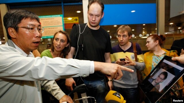 Phóng viên phỏng vấn một hành khách trên chuyến bay từ Hong Kong đến Moscow để xem ông Snowden có mặt trên chuyến bay này hay không, ngày 23/6/2013.