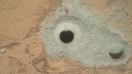 At the center of this image from NASA's Curiosity rover is the hole in a rock called "John Klein" where the rover conducted its first sample drilling on Mars. 