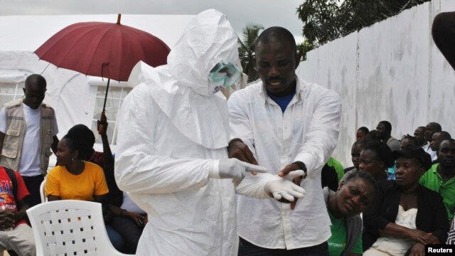A prática dos profissionais de saúde voluntários usando um equipamento de proteção individual (EPI) terno em um centro de tratamento de vírus Ebola recém-construída em Monrovia, Libéria, 21 de setembro de 2014.