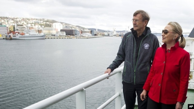 US Secretary of State Hillary Rodham Clinton, right, speaks with Jarle Aarbakke, Rector of the University of Tromso, aboard the Arctic Research Vessel Helmer Hanssen during a boat tour of the coastline with Norway's Minister of Foreign Affairs Jonas Gahr 