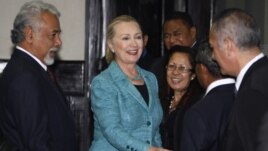 U.S. Secretary of State Hillary Clinton (C) shakes hands with staff members next to East Timor's Prime Minister Xanana Gusmao (L) at the Prime Minister's office in Dili September 6, 2012. 