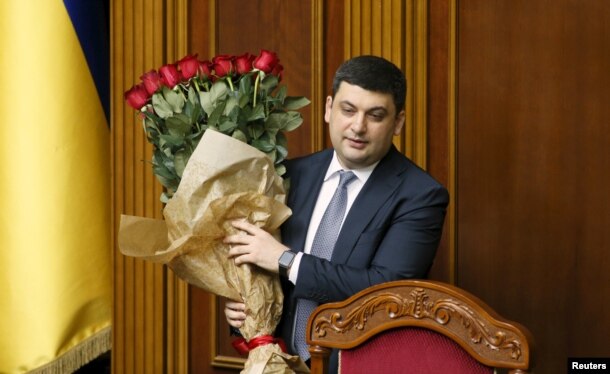 FILE - Newly-appointed Ukrainian Prime Minister Volodymyr Groysman holds a bouquet of flowers at the parliament in Kyiv, Ukraine, April 14, 2016.