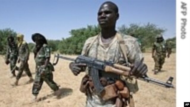 A JEM fighter escorts AU Force Commander General Martin Luther Agwai (third from left) and JEM's Khalil Ibrahim (second from left), in Darfur, October 2007. (AP)