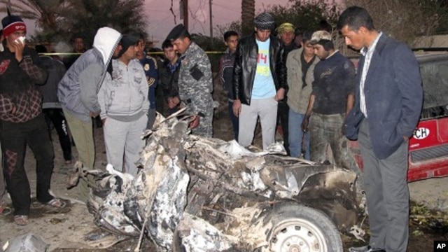 Residents and Iraqi soldiers inspect the site of a bomb attack in Hilla, 100 km (62 miles) south of Baghdad, December 5, 2011.
