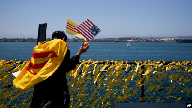 Ảnh minh hoạ: Một người Việt tị nạn cầu nguyện cho đất nước cạnh hàng rào với 60,000 nơ vàng vinh danh những người hy sinh trong chiến tranh Việt Nam trên hàng không mẫu hạm USS Midway ở San Diego, ngày 26/4/2015.