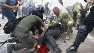 Cảnh sát giúp một người biểu tình bị thương trong vụ nổ ở Kyiv, ngày 31/8/2015.