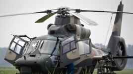 Flight crew of a Z-9WZ attack helicopter, designed and manufactured by China, chat after a flight demonstration for press at a Chinese Liberation Army base, ahead of Army Day on Aug. 1, on the outskirts of Beijing, China Tuesday, July 24, 2012.