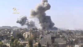 This image taken from video obtained from the Ugarit news network, which has been authenticated based on its contents and other AP reporting, shows smoke rising from the city following heavy bombing from military warplanes, in Deir el-Zour's Jbeileh neigh