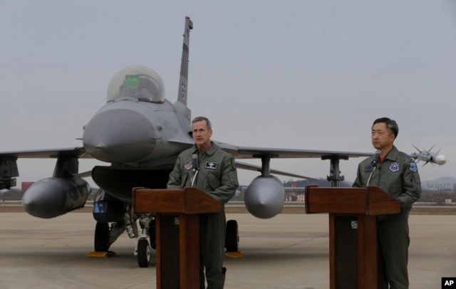 Lt. Gen. Terrence O'Shaughnessy, left, 7th Air Force commander of the U.S. Forces to Korea, speaks in front of a U.S. F-16 fighter jet as South Korean Air Forces Commander Lee Wang-geun listens at the Osan Air Base in Pyeongtaek, South Korea, Jan. 10, 201