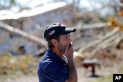 Clinton Moseley, quien vive con su madre, reacciona al daño causado por un gran árbol que cayó sobre la casa después del huracán Michael en Panama City, Florida.