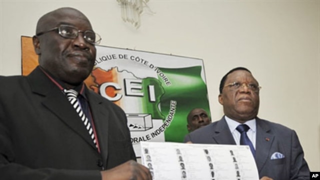 Director of Ivory Coast's Prime Minister Soro's Cabinet Paul Koffi (L) and president of Ivory Coast's Independent Electoral Commission (CEI) Youssouf Bakayoko (R) present the new provisional electoral list ahead of national elections in Abidjan, 12 Jul 20