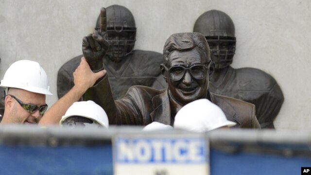Trabajadores remueven la estatua del legendario entrenador de fútbol colegial universitario, Joe Patterno, el domingo, en el estadio de Penn State.