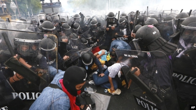 Thai policemen try to arrest anti-government protesters during their clash in Bangkok, Thailand Saturday, Nov. 24, 2012.