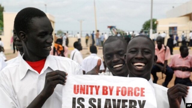 Southern Sudanese men hold a pro-independence poster as they wait for the arrival of envoys from the UN Security Council at the southern Sudanese capital Juba, 6 Oct 2010