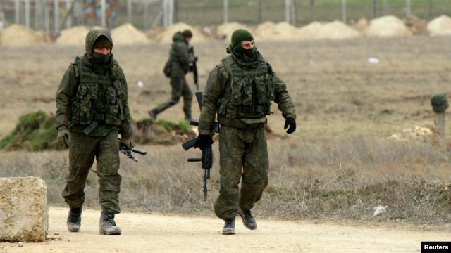 Những người đàn ông vũ trang, được cho là binh sĩ Nga, đi bộ tại cảng Yevpatoriya ở Crimea, ngày 8/3/2014.