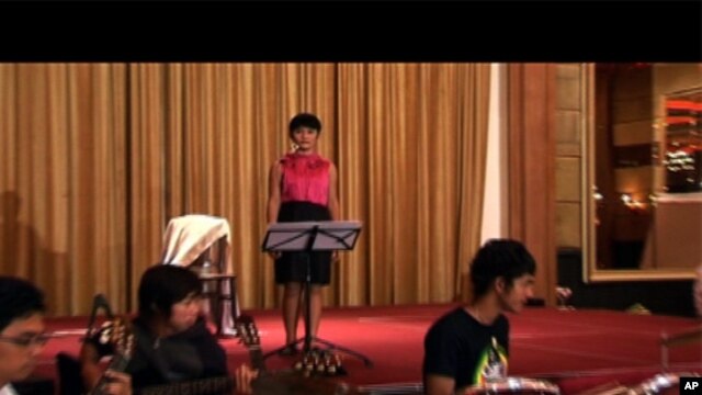 Panh Bosba practices singing with her band. 