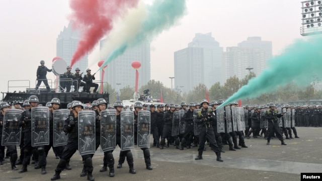 Policemen and members of the Special Weapons and Tactics practice dispersing crowds ahead of next week's 18th National Congress of the Communist Party of China, in Zhengzhou, Henan province, October 30, 2012.