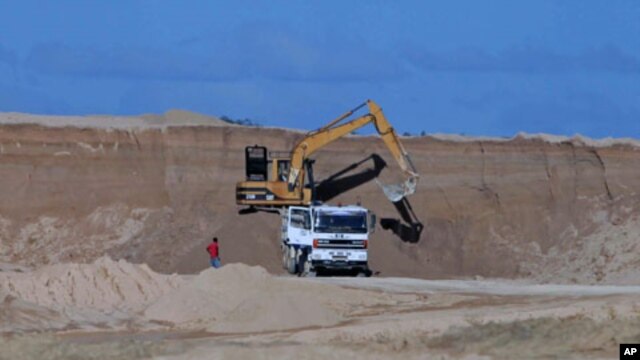 A excavator dumps bauxite ore into a dump truck at a mine belonging to China's Bosai Minerals Group in Linden, (File)