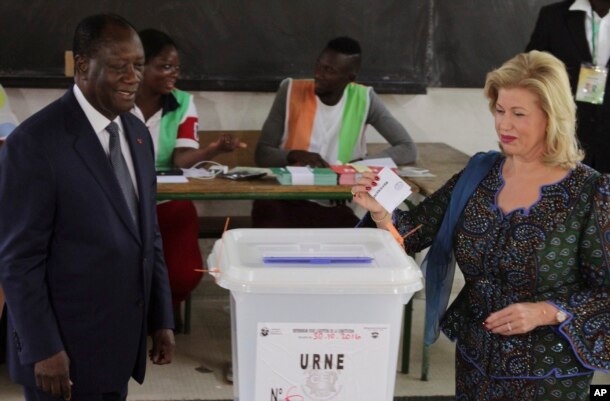 FILE - Ivory Coast's President Alassane Ouattara, left, and his wife, Dominique Ouattara, cast their ballots during the Ivory Coast referendum in Abidjan, Ivory Coast, Oct. 30, 2016.