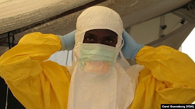 FILE - A health worker adjusts protective gear at a Doctors Without Borders' Ebola treatment unit in Conakry, Guinea. (VOA / Carol Guensburg) 