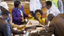 Official representatives of the various political parties and electoral workers discuss while reviewing newly received results, at the National Tallying Center in Nairobi, Kenya, March 6, 2013.