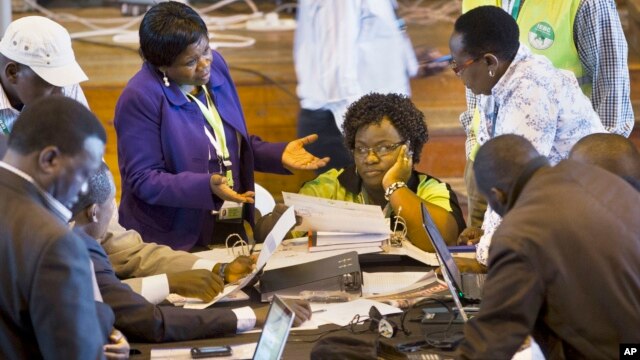 Official representatives of the various political parties and electoral workers discuss while reviewing newly received results, at the National Tallying Center in Nairobi, Kenya, March 6, 2013.