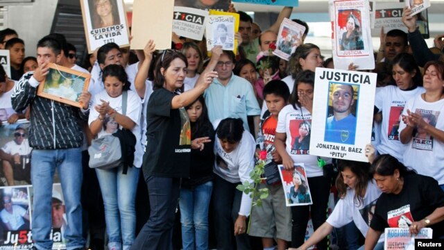 Maria Lujan Rey (C), mother of Lucas Menghini Rey, the last passenger found dead in the 2012 train crash at Once train station, throws flowers onto the railway track during a commemoration ceremony at the train station in Buenos Aires February 22, 2013. F