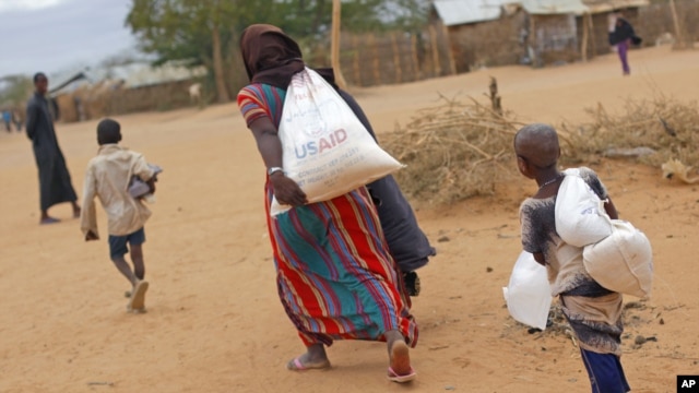 A newly arrived Somali family carry their supply of aid outside Dadaab, Eastern Kenya, Aug. 5, 2011. (AP)