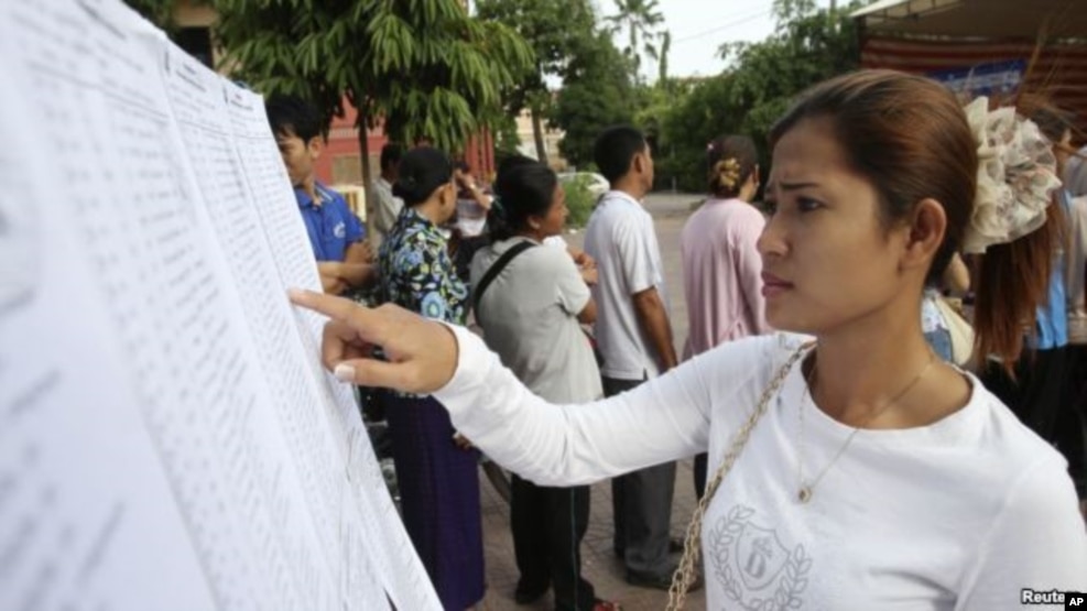 A woman finds her name on a list during a local commune election in Phnom Penh, file photo.