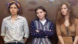 August 3, 2012: Pussy Riot members, from left, Nadezhda Tolokonnikova, Yekaterina Samutsevich and Maria Alekhina sit in a glass cage at a court room  in Moscow, Russia. 