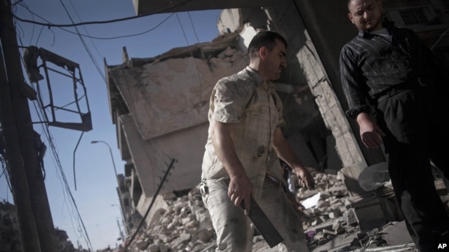 Syrian men salvage belongings from a destroyed buildings in the Bustan al-Qasr neighborhood of Aleppo, Syria, September 21, 2012.