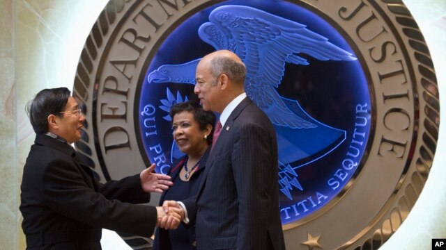 Attorney General Loretta Lynch, center, and Homeland Security Secretary Jeh Johnson, right, welcome Chinese Minister of Public Security Guo Shengkun to the Justice Department in Washington, Tuesday, Dec. 1, 2015.