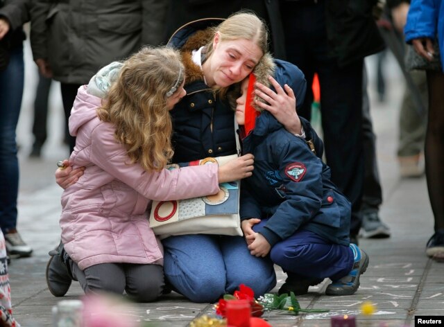 A woman consoles her children at a street memorial following Tuesday's bomb attacks in Brussels, Belgium, March 23, 2016.