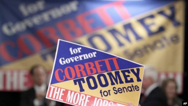 A supporter holds up a campaign sign as Pennsylvania Republican gubernatorial candidate Tom Corbett, Lt. Gov. candidate James Cawley and Pennsylvania Republican Senate candidate Senate Pat Toomey, appear during a rally in Pa., 01 Nov. 2010.