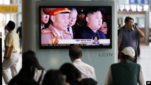South Korean passengers watch a news reporting about the North Korea's army chief Ri Yong Ho's departure on a TV screen at the Seoul train station in Seoul, South Korea, July 17, 2012.