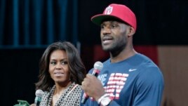 First lady Michelle Obama looks at Cleveland Cavaliers' basketball player LeBron James as he speaks at The University of Akron