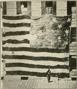 A soldier guards the original Fort McHenry. Note his size and that of the flag. (Wikipedia Commons)