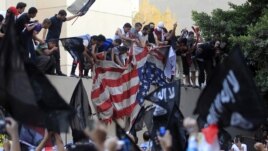 Protesters destroy an American flag pulled down from the U.S. embassy in Cairo, September 11, 2012.