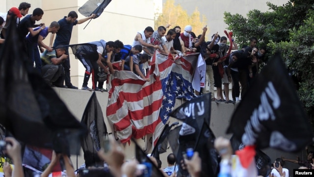 Protesters destroy an American flag pulled down from the U.S. embassy in Cairo, September 11, 2012.