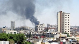 Smoke rises from buildings hit by shelling in Homs, Syria