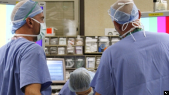 Jazmine Raygoza is prepared for Lap-Band surgery by anesthesiologist Dr. Andrea Grilli (C) Surgical First Assistant Tony Covello (R) and Dr. Michael Snyder (L) at Rose Medical Center in Denver June 20, 2011 . After trying multiple diets and exercise, Jazm