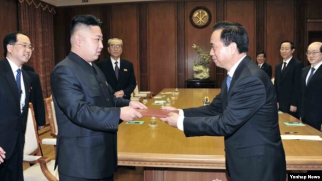 지난해 11월 중국 공산당 대표단으로부터 시진핑 공산당 총서기의 친서를 전달받은 김정은 북한 국방위원회 제1위원장(왼쪽). (자료사진)