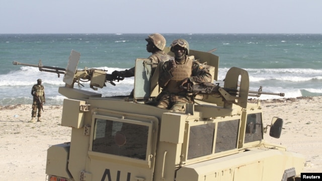 Peacekeepers from the African Union Mission in Somalia man weapons atop their Armored Personnel Carrier after capturing the former private Elmaan seaport from al-Shabaab insurgents, 30km (19 miles) east of Mogadishu, September 4, 2012.  