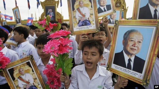 Cambodian students hold portraits of former King Norodom Sihanouk during an Independence Day celebration in Phnom Penh, Cambodia, Nov. 9, 2011.