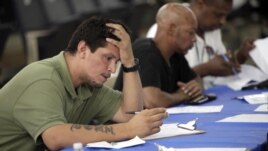 Job seekers fill out applications at a construction job fair in New York, August 21, 2012.