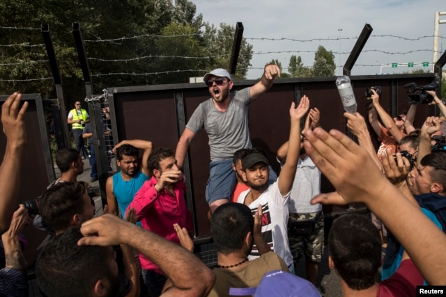 Migrants shout to open the border near the village of Horgos, Serbia, Sept. 15, 2015.