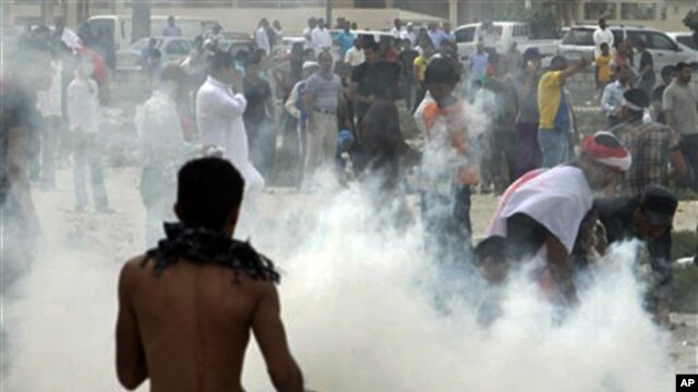 Anti-government protesters react to tear gas fired by riot police along a main highway in Manama, Bahrain, March 13, 2011